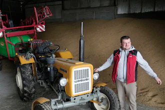 Piotr Korycki stands in a warehouse filled with grain on his farm in Cywiny Wojskie, Poland, March 18, 2024.
