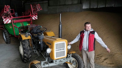 Piotr Korycki stands in a warehouse filled with grain on his farm in Cywiny Wojskie, Poland, March 18, 2024.