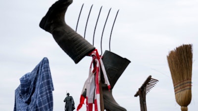 A farmer's shirt, boots, pitchfork and broom displayed during protest in Berlin, March 22, 2024.