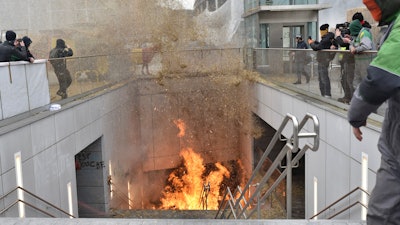 A fire burns in a stairwell outside the European Council building in Brussels, March 26, 2024.