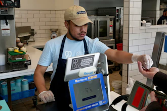 An employee collects payment at an Auntie Anne's and Cinnabon store in Livermore, Calif., March 28, 2024.