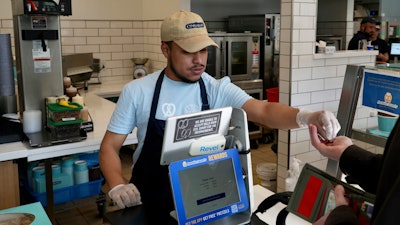 An employee collects payment at an Auntie Anne's and Cinnabon store in Livermore, Calif., March 28, 2024.