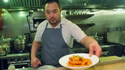 David Chang presents a dish at Momofuku Noodle Bar in New York, Nov. 10, 2011.