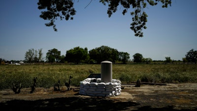 Sandbags stacked around a well in anticipation of flooding on the Kings River, Lemoore, Calif., April 19, 2023.