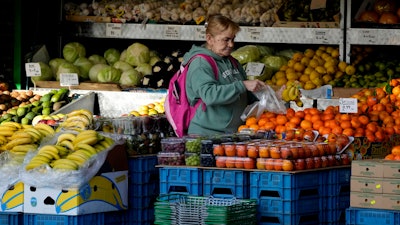 A woman selects fruits at a supermarket in London, Nov. 17, 2021.