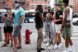 People wait for takeout drinks at a bar in the Hell's Kitchen neighborhood of New York, May 29, 2020.