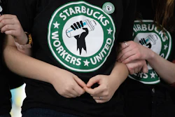 Starbucks employees and supporters link arms during a union election watch party, Buffalo, N.Y., Dec. 9, 2021.