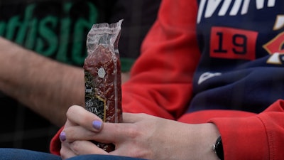 A Minnesota Twins fan holds a sausage before a baseball game against the Chicago White Sox in Chicago, April 29, 2024.