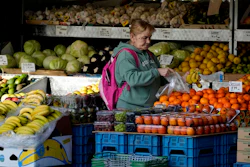 A woman selects fruits at a supermarket in London, on Nov. 17, 2021. Inflation in the U.K. fell to its lowest level in two and a half years in March after a further easing in food prices, official figures showed Wednesday, April 17, 2024.