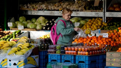 A woman selects fruits at a supermarket in London, on Nov. 17, 2021. Inflation in the U.K. fell to its lowest level in two and a half years in March after a further easing in food prices, official figures showed Wednesday, April 17, 2024.