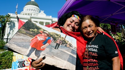 Farmworkers Cynthia Burgos, left, and Teresa Maldonado at a bill-signing ceremony in Sacramento, Calif., Sept. 28, 2022.