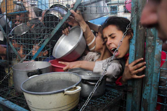 Palestinians line up to receive meals at Jabaliya refugee camp in the Gaza Strip, March 18, 2024.
