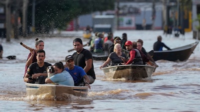 Volunteers help evacuate residents from an area flooded by heavy rains, Porto Alegre, Brazil, May 7, 2024.