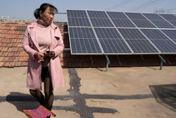 Shi Mei walks near solar panels on her rooftop outside Jinan, China, March 21, 2024.