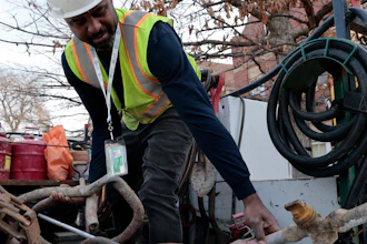 Blackhawk Sewer & Water contractor Khaild Waarith holds a lead pipe that was extracted in Chicago, April 10, 2023.