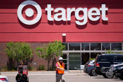 A worker collects shopping carts in the parking lot of a Target in Highlands Ranch, Colo., June 9, 2021.