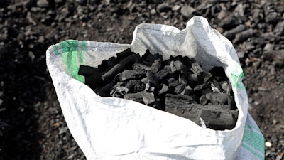 A sack of charcoal is filled in Gulu, Uganda, May 27, 2023.