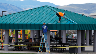 Workers paint the roof a picnic area in Clement Park, Littleton, Colo., April 17, 2024.