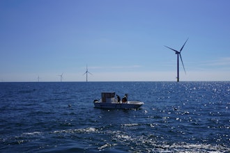 Workers aboard a small boat check lines of seaweed and mussels crops at Kriegers Flak offshore wind farm.