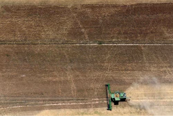 Farmers harvest a grain field near Wernigerode, Germany.