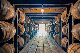 Wooden bourbon barrels stacked up and aging in a rickhouse in Kentucky.