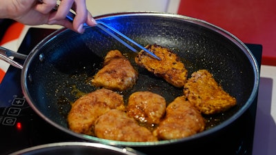 Chef Mika Leon cooks cultivated chicken at a pop-up tasting for 'lab-grown' meat produced by California-based Upside Foods.