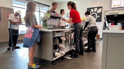 Workers serve customers at a fast food restaurant in Denver, June 27, 2024.