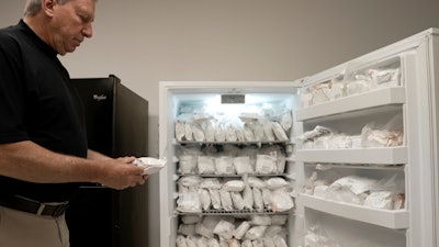 David Ayares, president and chief scientific officer of Revivicor, holds a package of frozen meat during an interview at the company’s offices in Blacksburg, Va., on May 30, 2024. His company genetically modified pigs, known as GalSafe pigs, so they no longer carry a sugar responsible for alpha-gal syndrome, an allergy to red meat.