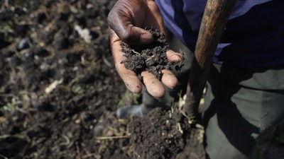Benson Wanjala sifts through a sample of soil at his farm in Machakos, Kenya, May 21, 2024.