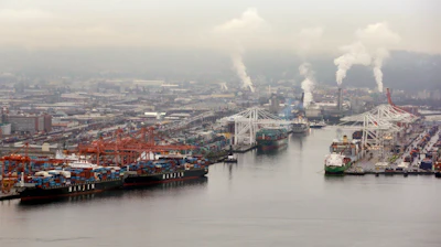 Container ships are docked at the Port of Seattle along the Duwamish River in Seattle.