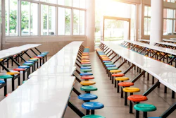 Modern school cafeteria with empty seats and tables.