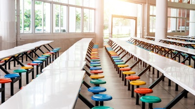 Modern school cafeteria with empty seats and tables.