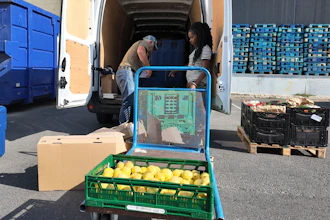 Manuel Pintos, a volunteer for Le Maillon, loads goods into a vehicle.
