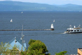 Sailboats and a passenger ferry dot Lake Champlain as seen from Battery Park in Burlington, Vt.