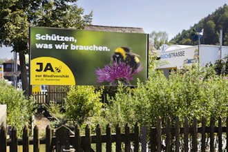 A poster for the Yes campaign is seen in a garden ahead of a biodiversity referendum, Belp, Switzerland.
