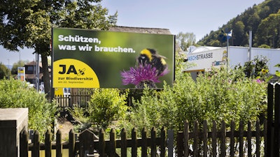 A poster for the Yes campaign is seen in a garden ahead of a biodiversity referendum, Belp, Switzerland.