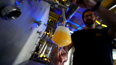Head Brewmaster Tobias Zollo fills beer at the Weihenstephan brewery in Freising, Germany, Sept. 20, 2024.