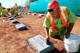 Steven Abujen, a California prison inmate with the Prison Industry Authority, cleans one of the newly installed headstones at the Mormon Island Relocation Cemetery near Folsom, Calif., Oct. 18, 2011.