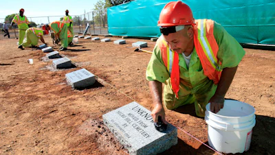 Steven Abujen, a California prison inmate with the Prison Industry Authority, cleans one of the newly installed headstones at the Mormon Island Relocation Cemetery near Folsom, Calif., Oct. 18, 2011.