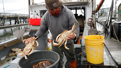 Fisherman Mike Vorak sells Dungeness crabs off his boat at Pillar Point Harbor, Half Moon Bay, Calif., Dec. 29, 2021.