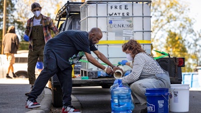 Volunteers with BeLoved Asheville fill bottles of drinking water, Asheville, N.C., Oct. 8, 2024.