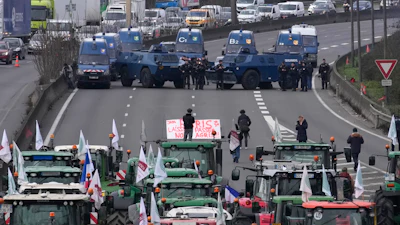 Gendarmes with armored vehicles face farmers and their tractors blocking a highway, Jan. 31, 2024, Chilly-Mazarin, France.