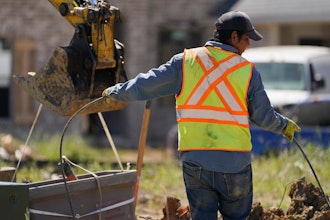 A worker lays a cable at a home building site in Flowood, Miss. on Sept. 23, 2021.