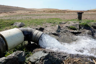Well water flows from pumps into a canal that will be used to irrigate a vineyard,, July 25, 2022, Rio Vista, Calif.