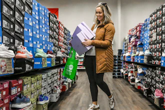 Ashley Crafton looks at tennis shoes at at Shoe Stop while shopping during Small Business Saturday in Wesleyan Park Plaza on Nov. 25, 2023, in Owensboro, Ky.