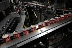 Coca-Cola cans move down a conveyer belt at the Swire Coca-Cola bottling plant, Denver, Oct. 20, 2023.