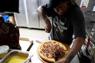 TiAnna Yeldell, a 44-year-old single mom of three, works in the kitchen at Pizza Hut, Nov. 14, 2024, Missouri City, Texas.