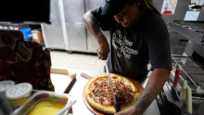 TiAnna Yeldell, a 44-year-old single mom of three, works in the kitchen at Pizza Hut, Nov. 14, 2024, Missouri City, Texas.