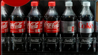 Bottles of Coca Cola in a refrigerated case at Coors Field, Denver, April 19, 2024.