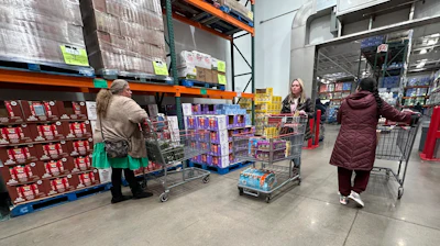 Shoppers guide their carts through the milk display in a Costco warehouse Thursday, Jan. 23, 2025, in Sheridan, Colo.